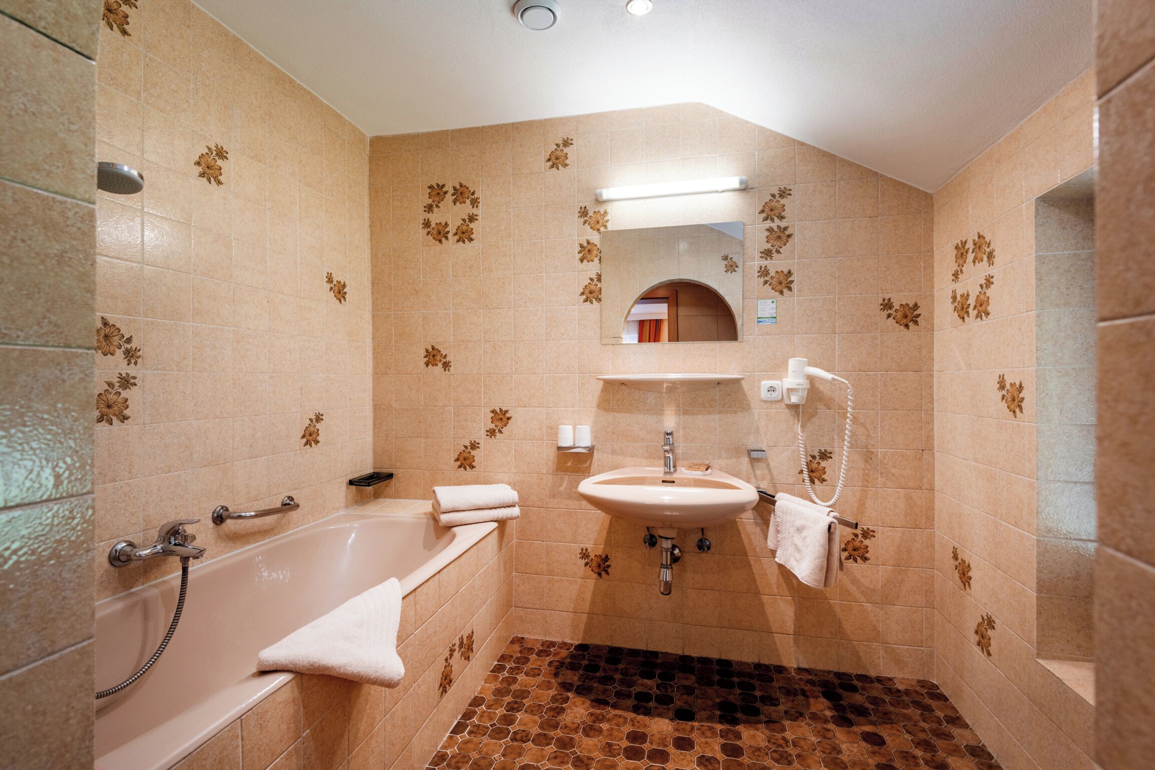 Un baño con bañera, lavamanos y espejo.
