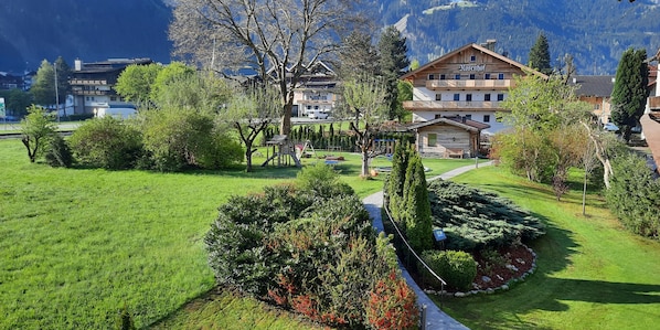 A hotel with a garden, a playground, and a mountain backdrop. - Gästehaus Birkenhof (Mayrhofen)