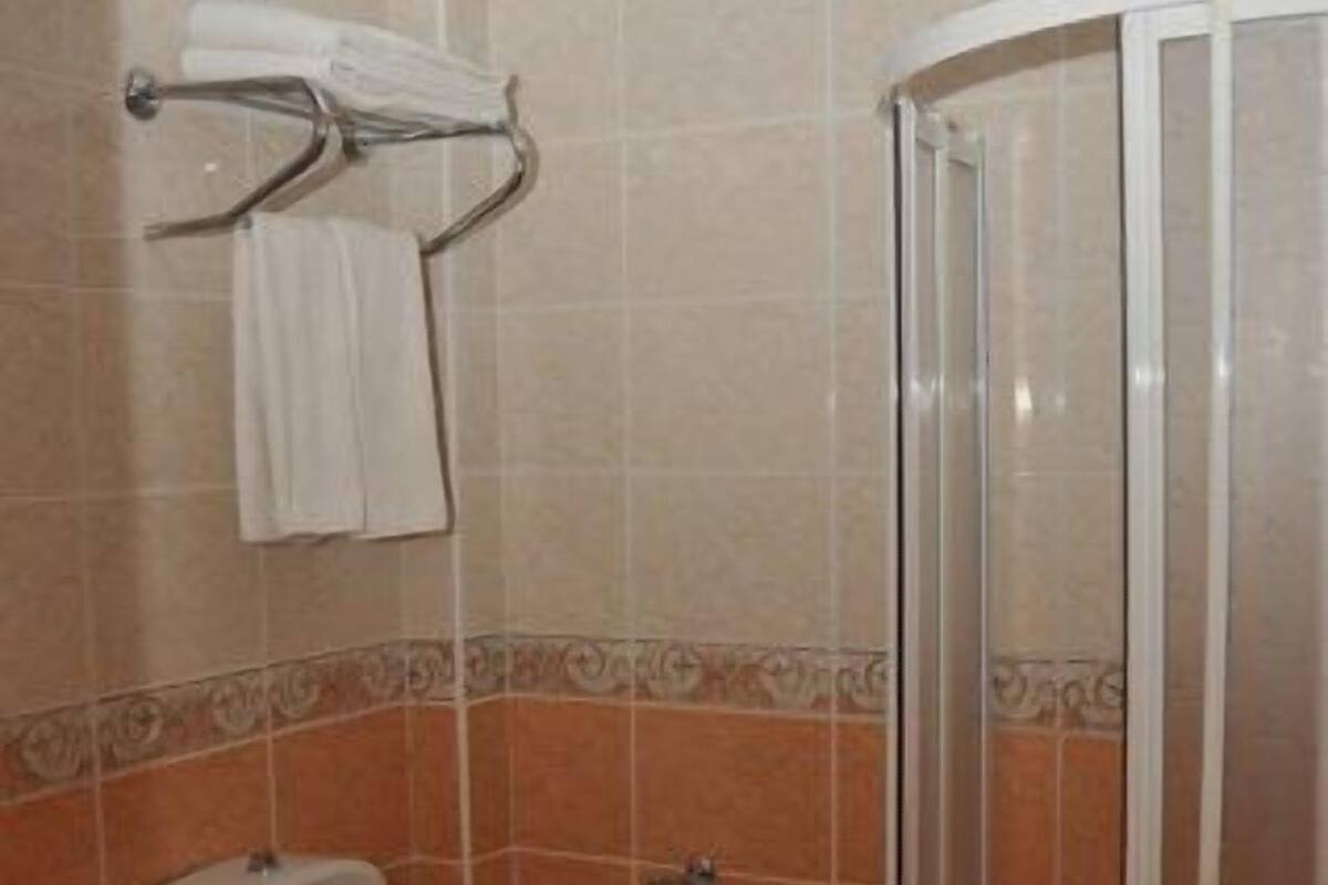 A bathroom with a toilet, a sink, and a shower stall.