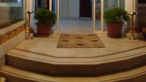 A grand entrance with a marble staircase, potted plants, and a glass door leading inside. - Inside Hotel (Manavgat)