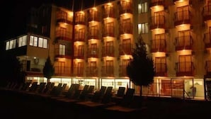 A multi-story hotel with balconies and a row of sun loungers in the foreground. - Inside Hotel (Manavgat)
