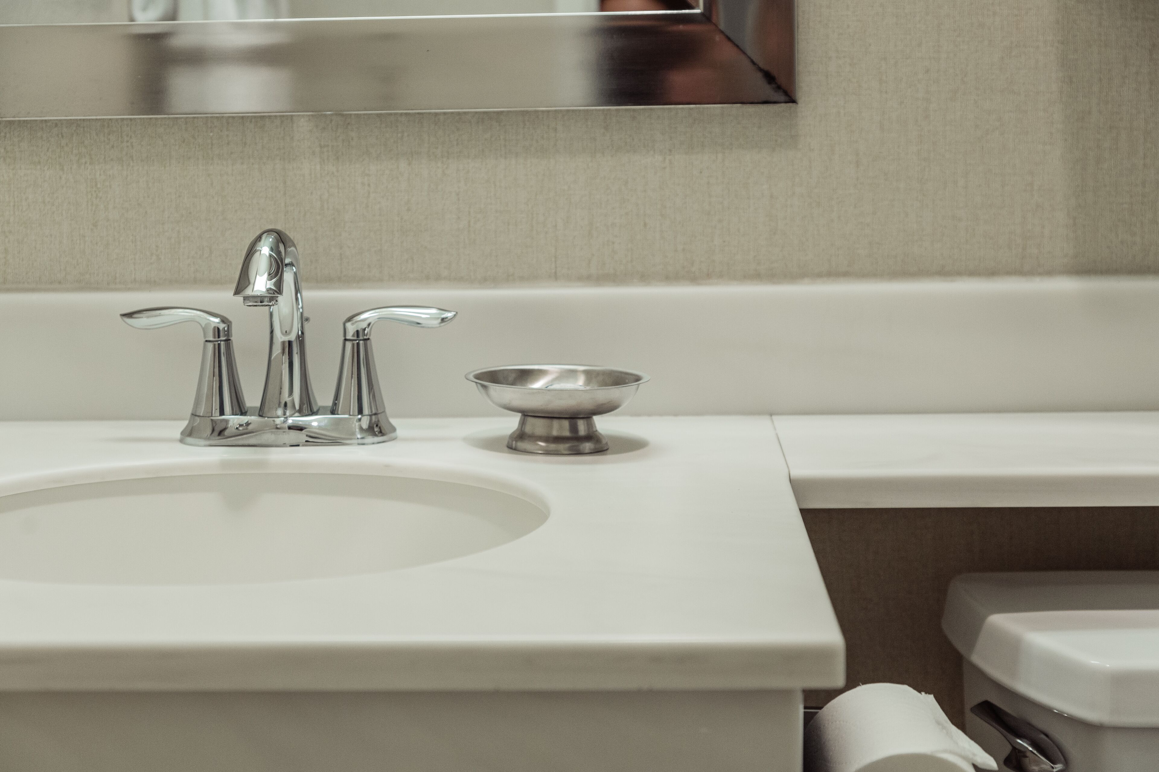 Un lavabo moderne avec un seul robinet et un petit bac.