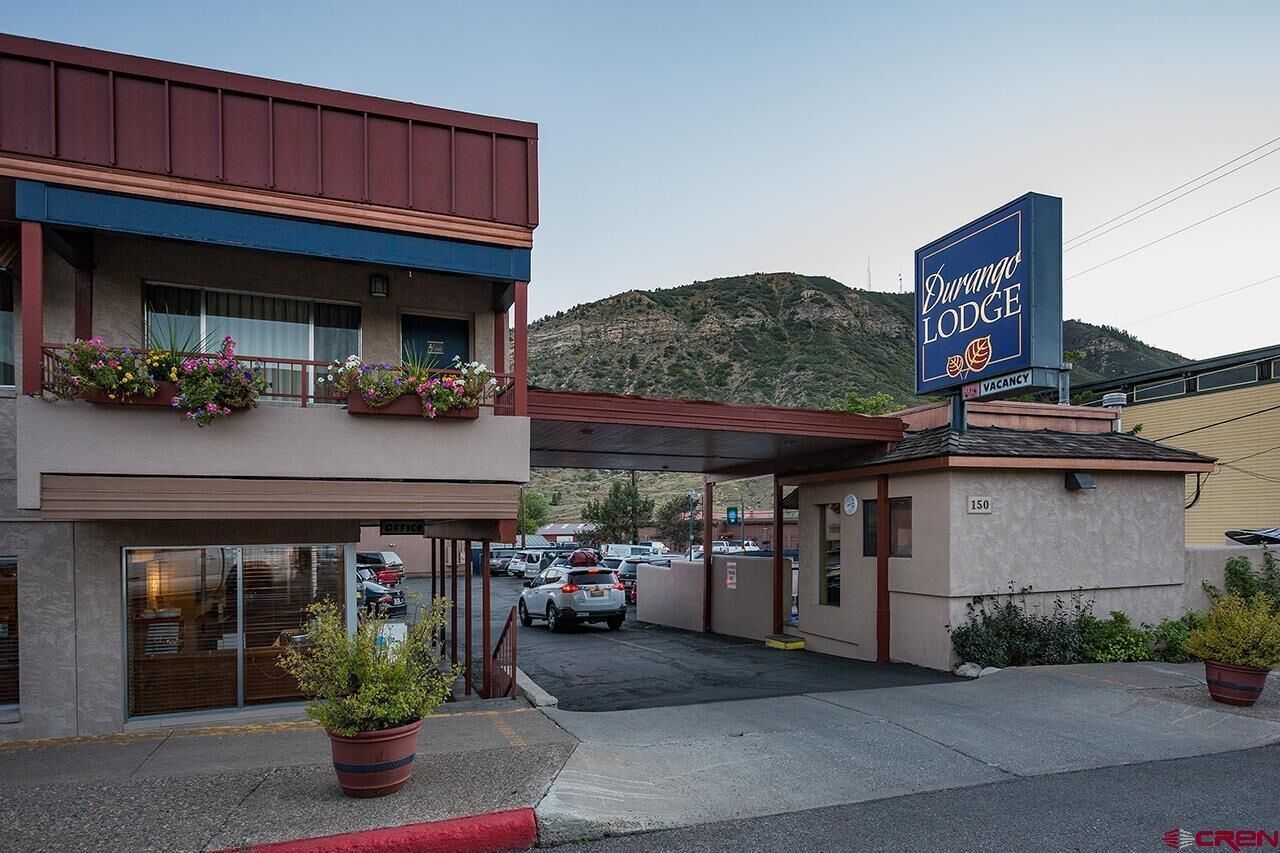 A Durango Lodge with a parking lot, a covered entrance, and a mountainous backdrop.