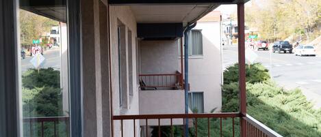 A balcony with a view of a street and parked cars.