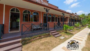 A building with a red facade, arched windows, and a sign that reads "SANG JAHH". - Cowboy Farm Resort Pattaya (Bang Lamung)