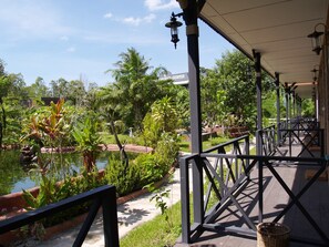 A covered outdoor area with a pool, surrounded by lush greenery and a clear sky. - Cowboy Farm Resort Pattaya (Bang Lamung)