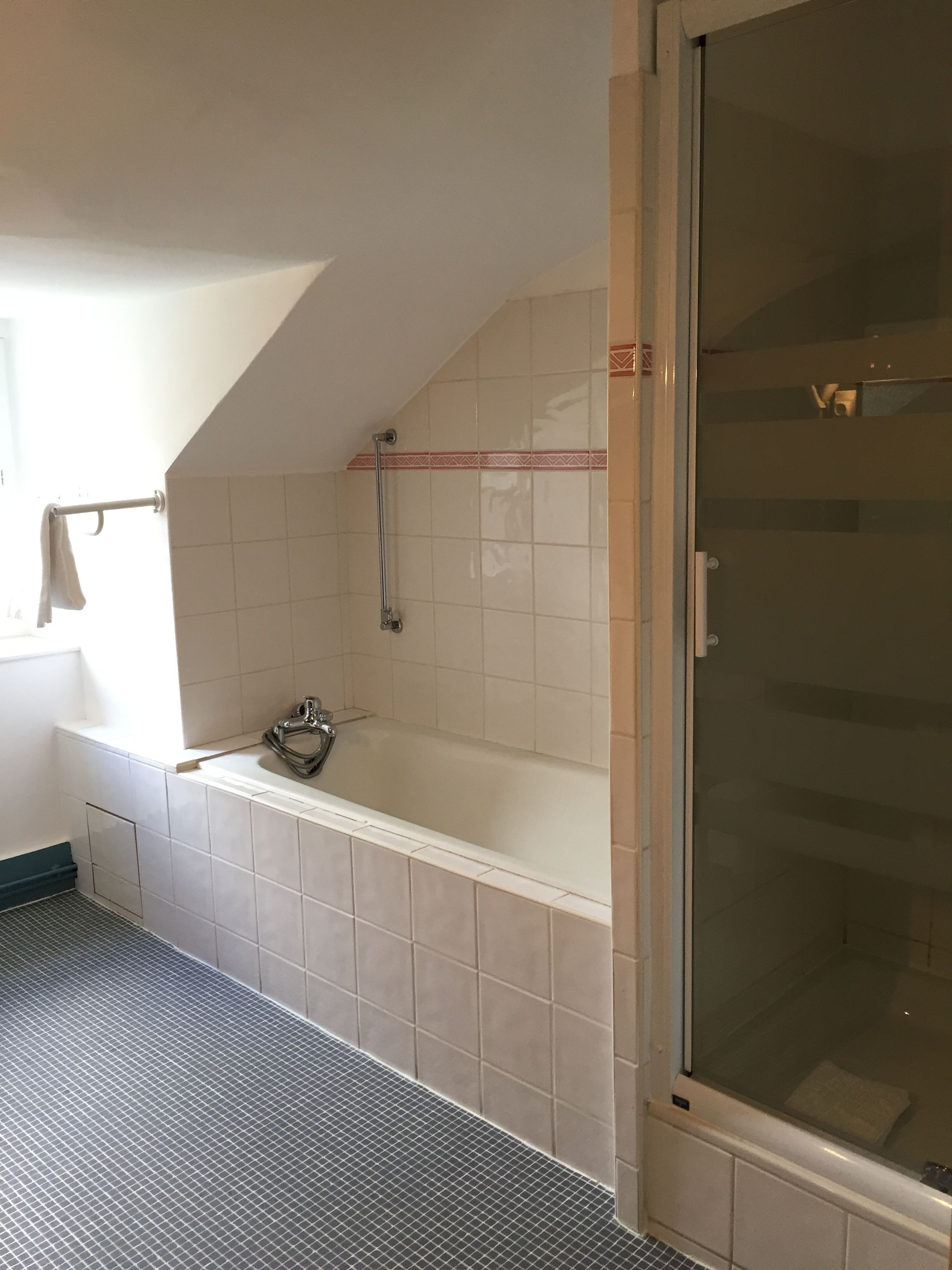 A bathroom with a bathtub, a shower, and a tiled floor.