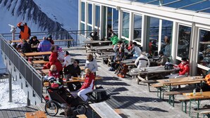 A rooftop terrace with outdoor seating and a view of snow-covered mountains. - Hotel Traube – Stelvio (Stelvio)