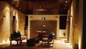 Un intérieur moderne avec un mur en pierre, un coin repas et des sièges.