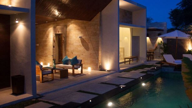 Une maison moderne dotée d’une piscine, d’un espace extérieur aménagé et d’un intérieur bien éclairé.