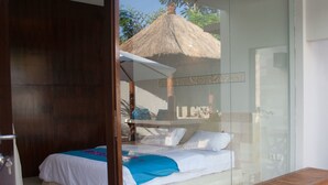 Une chambre à coucher avec un lit, un banc et un mur en verre.