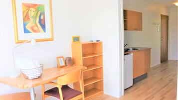 Una cucina compatta con mobili in legno, un piccolo ripiano e una lavastoviglie integrata.