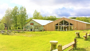 A barn with a glass facade and a wooden structure with large windows. -  Veghús Guesthouse (Selfoss)