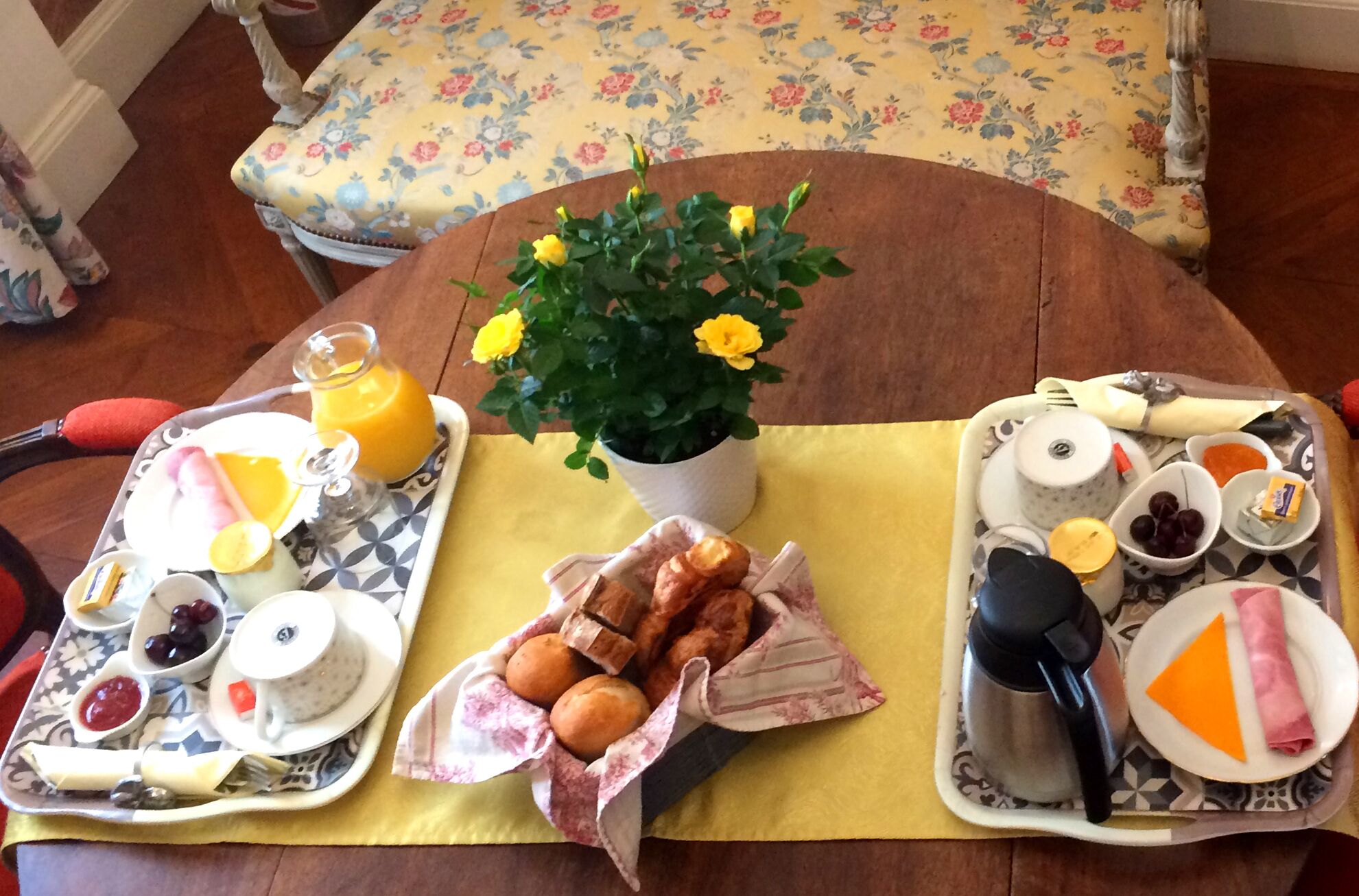Una mesa con dos fuentes de comida, una planta en maceta y una cafetera.