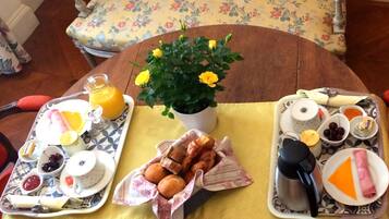 Una mesa con dos fuentes de comida, una planta en maceta y una cafetera.