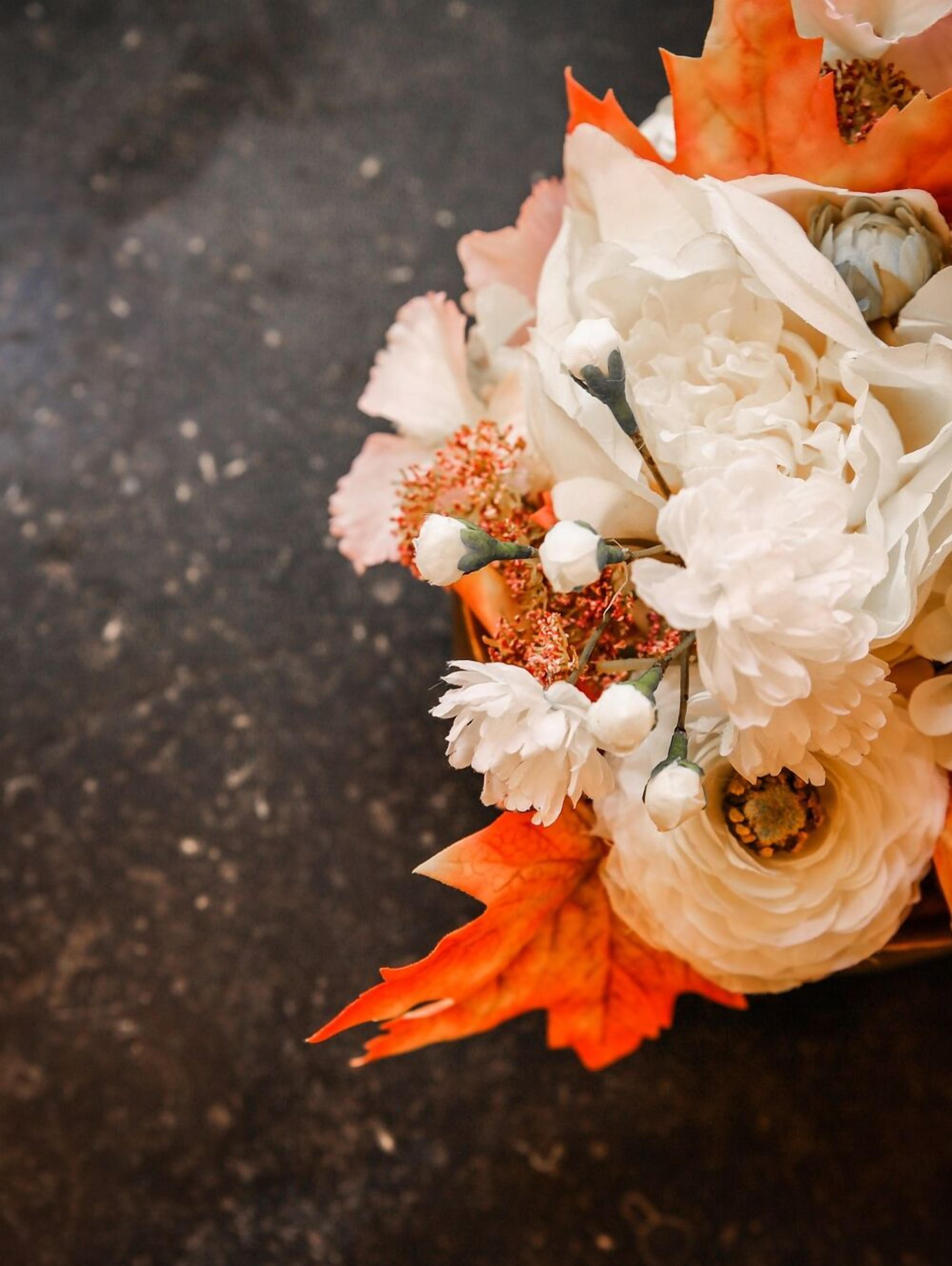 Un ramo de flores con pétalos blancos y anaranjados.