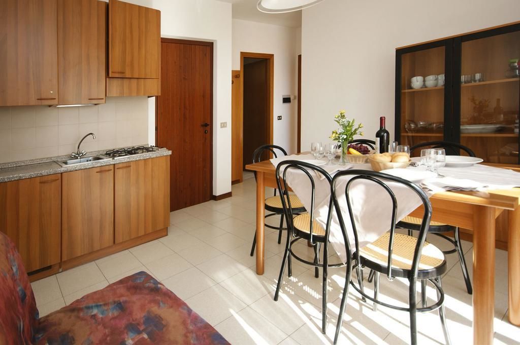 Una cocina moderna con armarios de madera y un comedor con mesa dispuesta para cuatro.