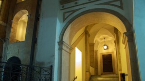 A grand staircase with a chandelier, leading to a door at the top. - Palazzo De Cupis (Rome)