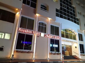 The exterior of the Royalton Hotel with a prominent sign, large windows, and a staircase leading to the entrance. - Royalton Hotel Dubai (Dubai)
