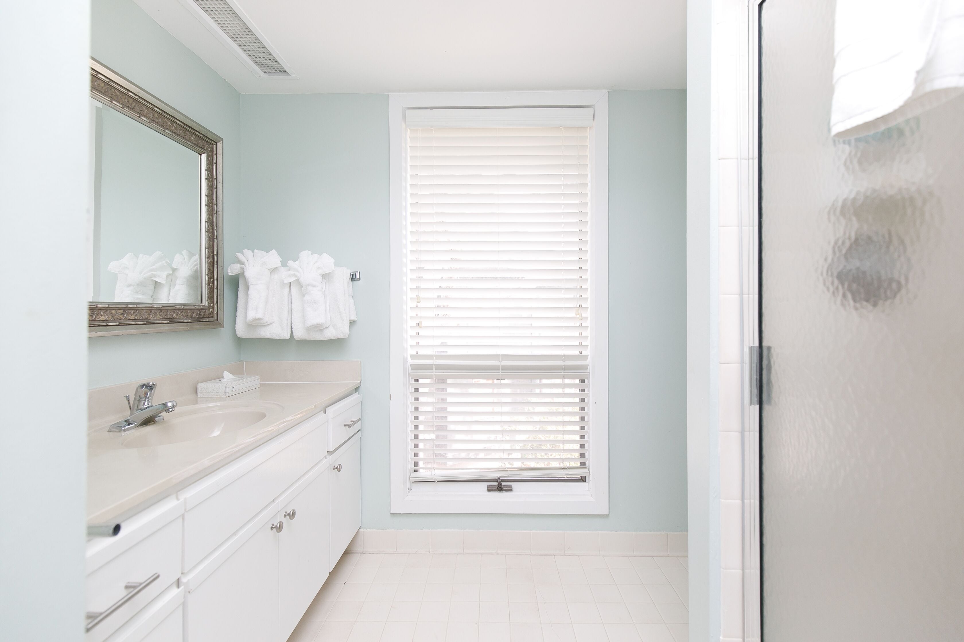 A bathroom with a sink, mirror, and towel rack.
