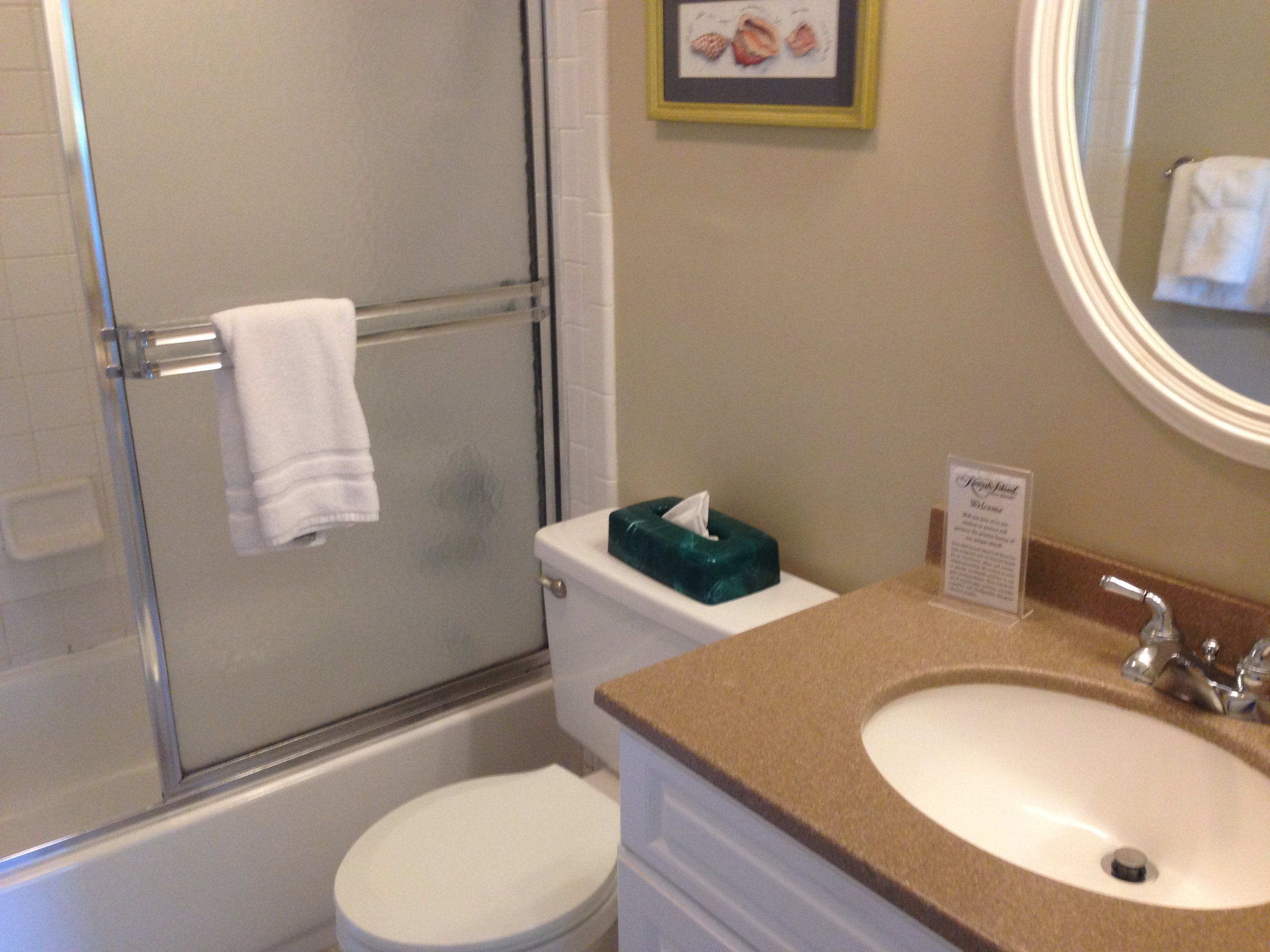 Une salle de bain avec une douche à parois de verre, des toilettes et un lavabo avec un meuble-vasque.