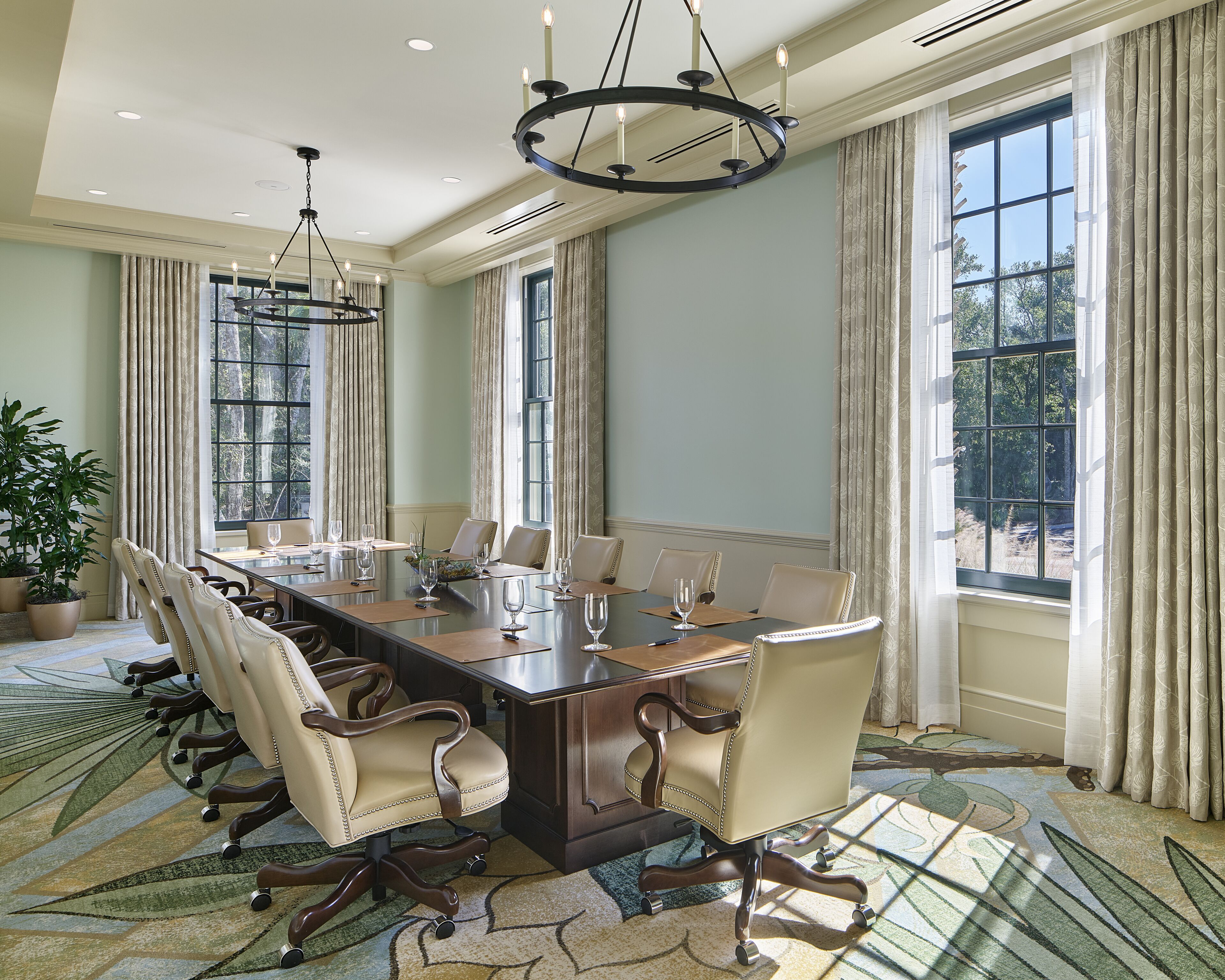 A conference room with a long table, multiple chairs, and a chandelier.