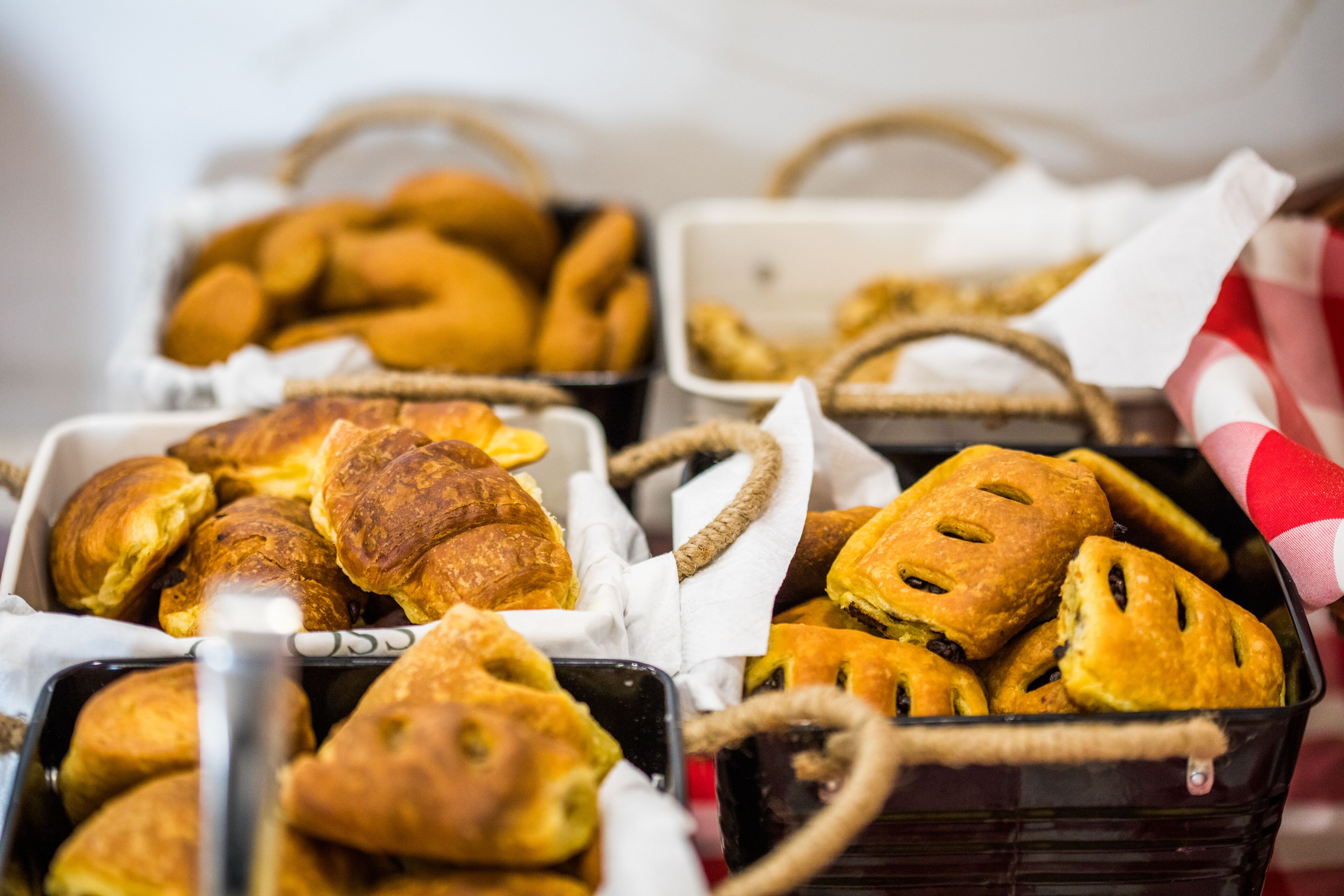 A variety of baked goods in baskets, including croissants and pastries.