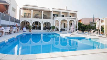 Una piscina al aire libre, sillones reclinables de piscina