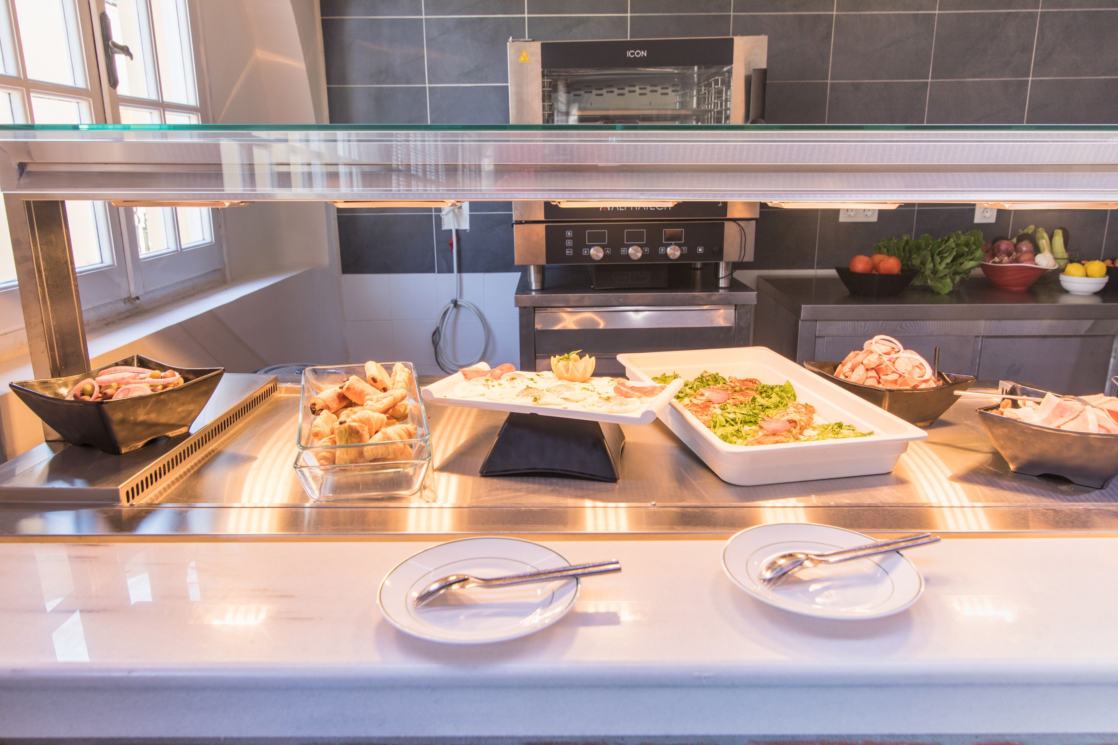 A buffet setup with various food items and utensils.
