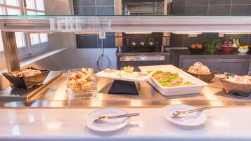 A buffet setup with various food items and utensils.