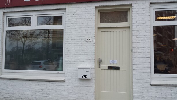 A white brick building with a beige door marked '72B'. - Hotel Chao (Utrecht)