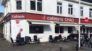 A cafe named Cafetaria Chao with outdoor seating and a Coca-Cola advertisement. - Hotel Chao (Utrecht)