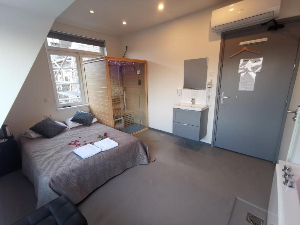 Ein Schlafzimmer mit Bett, Kleiderschrank, Badezimmer und Fenster.