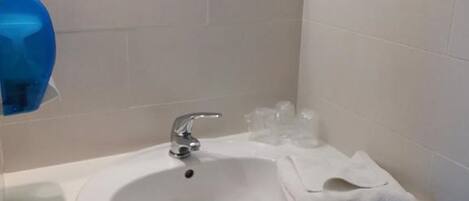 A bathroom with a white sink, a mirror, and a towel rack.