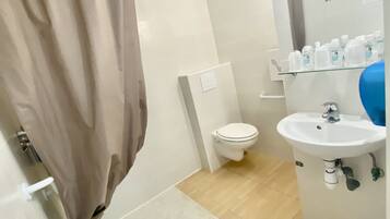Un baño con cortina de ducha, inodoro, lavabo y espejo.