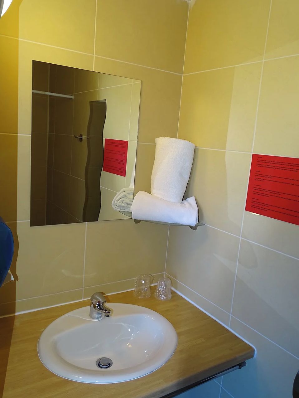 A bathroom with a white sink, a mirror, and a towel rack.