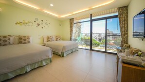 A hotel room with two beds, a balcony with a view, and a TV on the wall. - Ciao House (Hengchun)