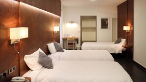 Une chambre d’hôtel avec deux lits, un bureau, une chaise et un ventilateur de plafond.