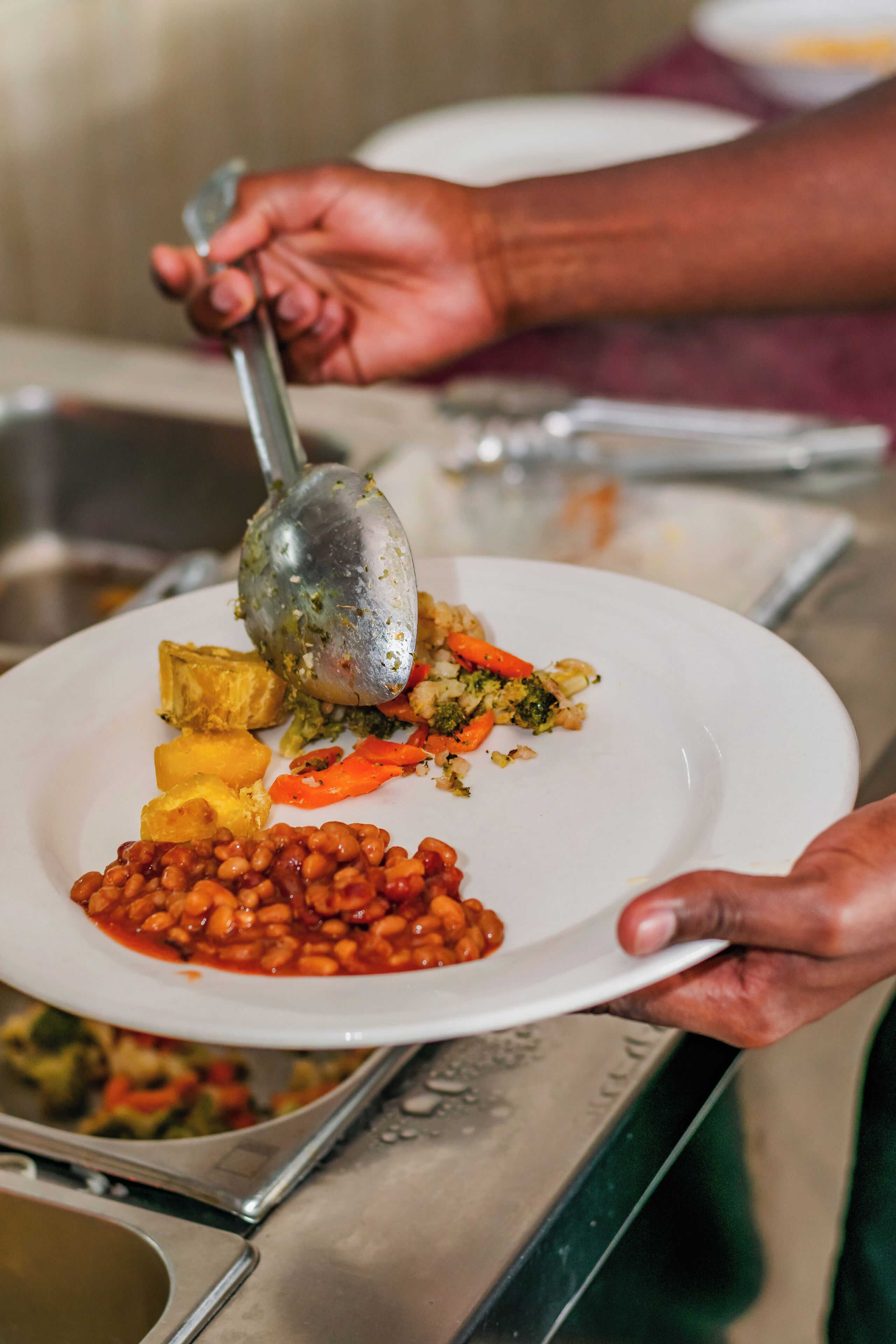 A person serving food from a buffet.