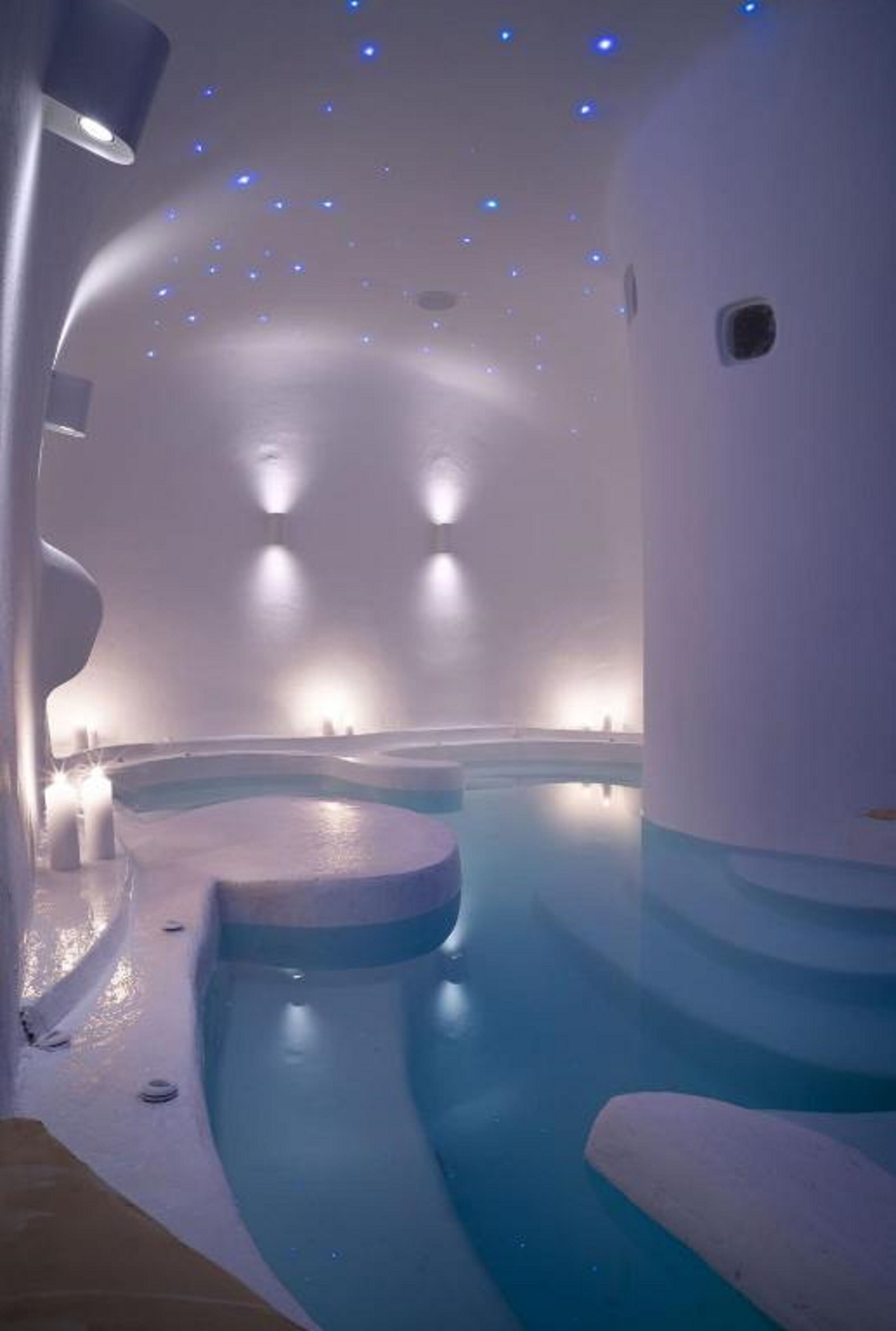 Een moderne spa met een groot, gebogen bubbelbad en sfeerverlichting.