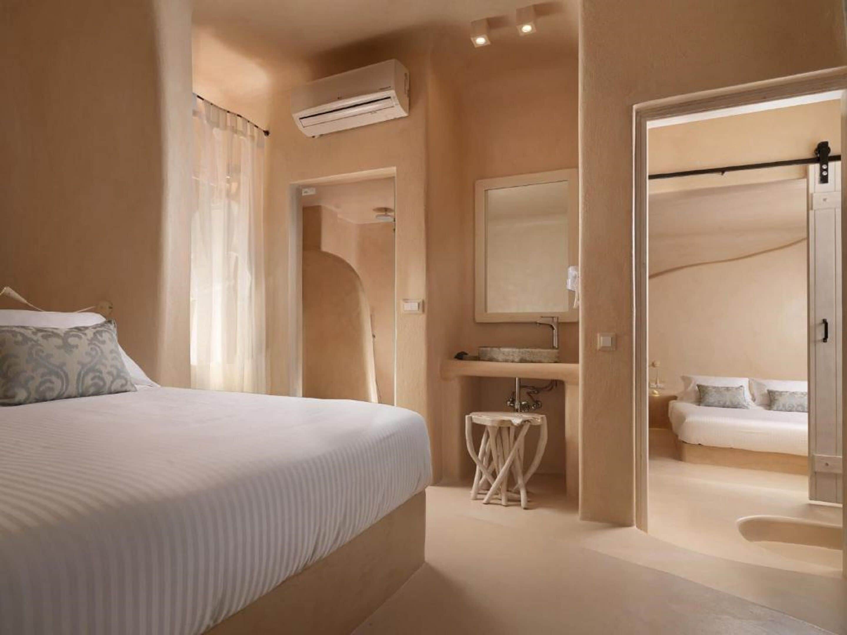 Une chambre à coucher comprenant un lit, une table de chevet, un miroir et une salle de bain avec un lavabo et des toilettes.