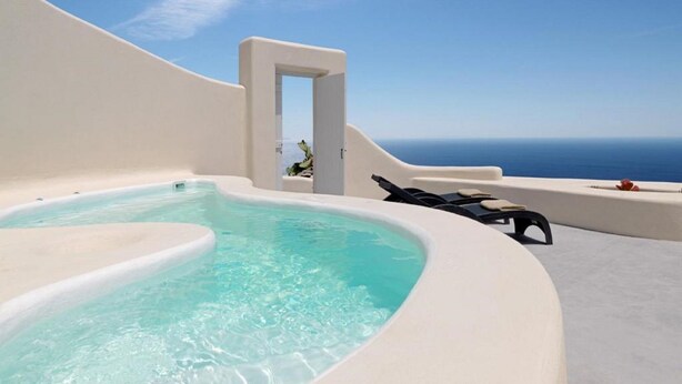 Un jacuzzi con vista despejada al océano, una pared blanca y un acceso.