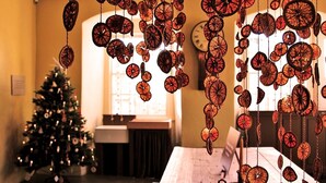 A room with a Christmas tree, a clock on the wall, and hanging decorations. - Brocks Guest House (Bath)