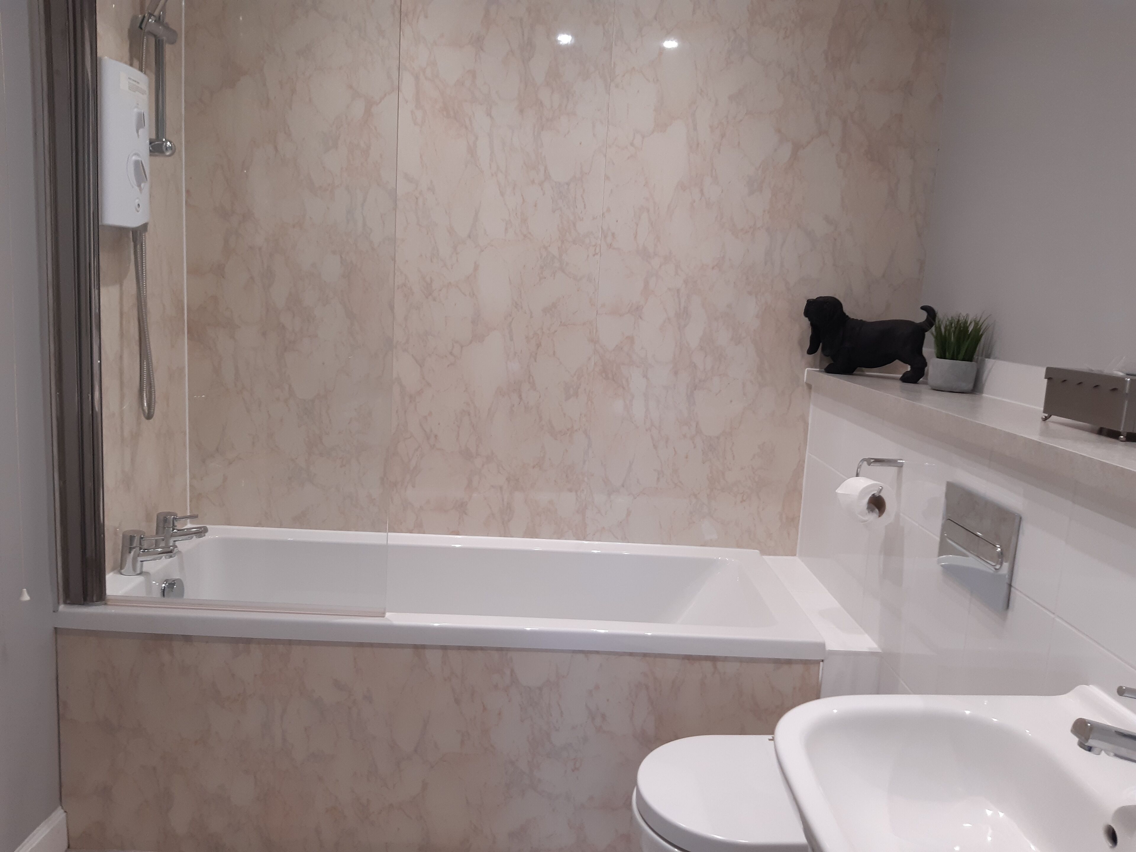 A modern bathroom with a bathtub, toilet, and sink.