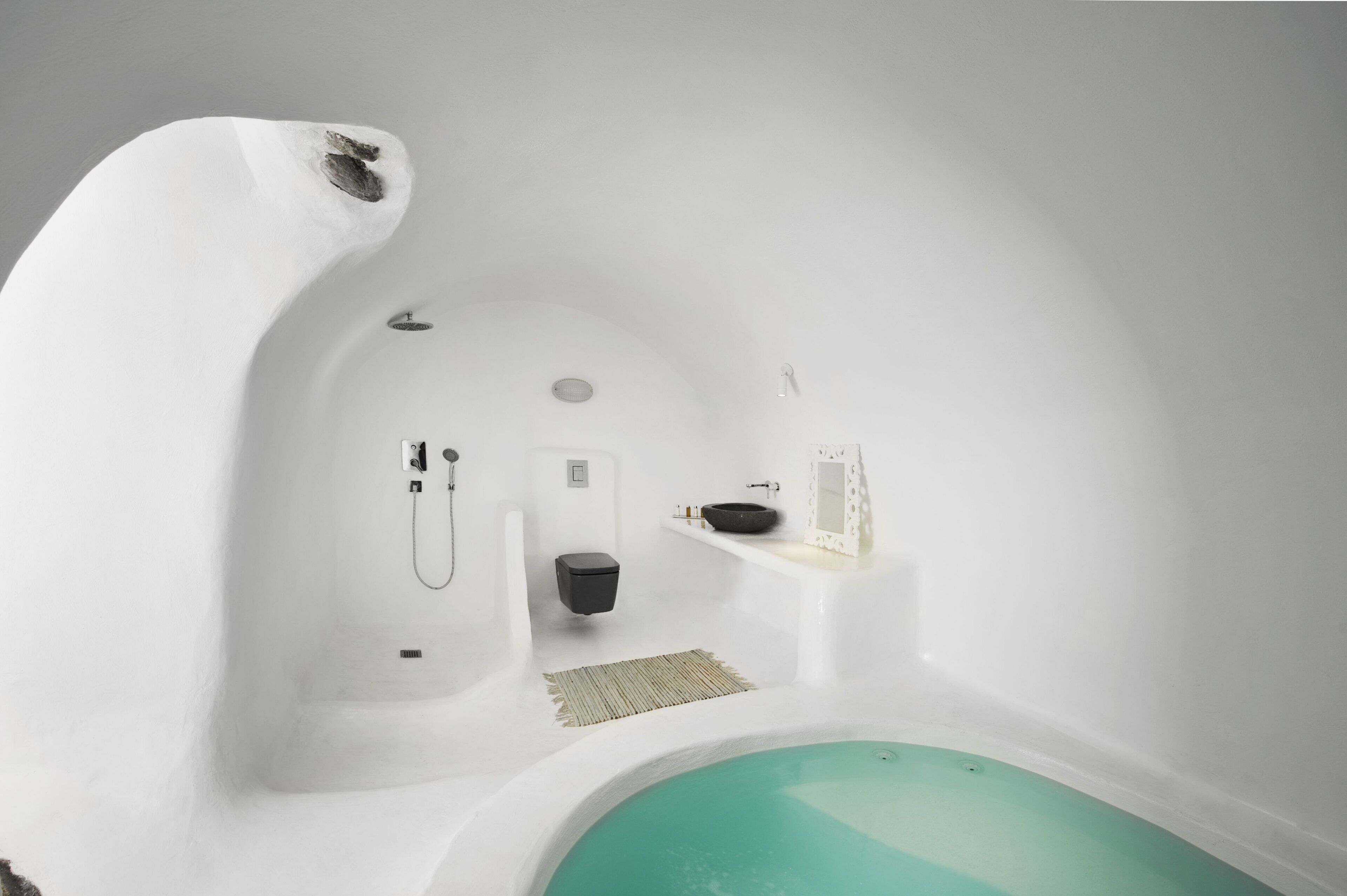Une salle de bain moderne et minimaliste, dotée d’une baignoire sur pieds, de toilettes et d’un lavabo.