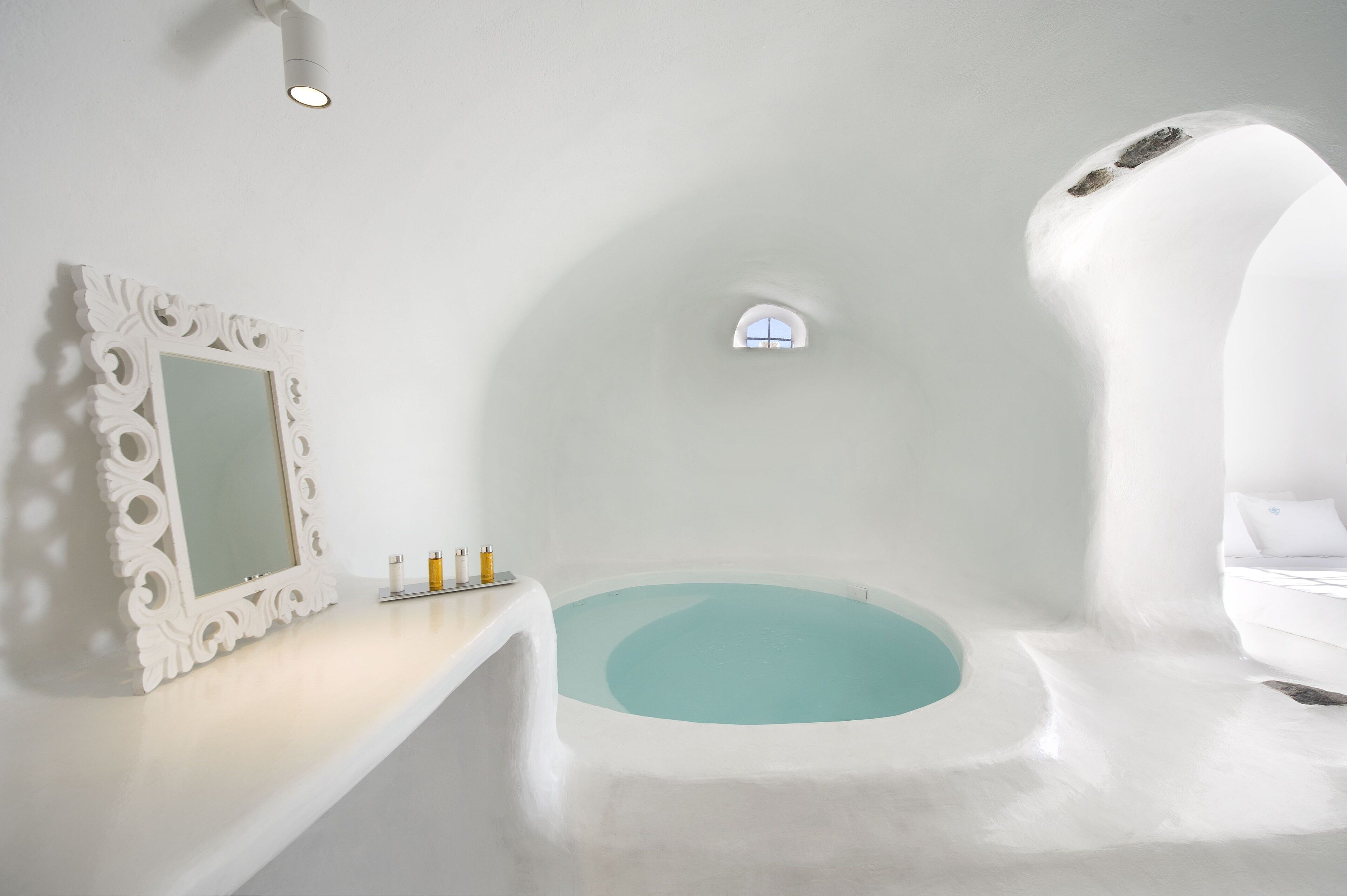 Un bagno moderno con una vasca autonoma, un ampio specchio e una piccola finestra.