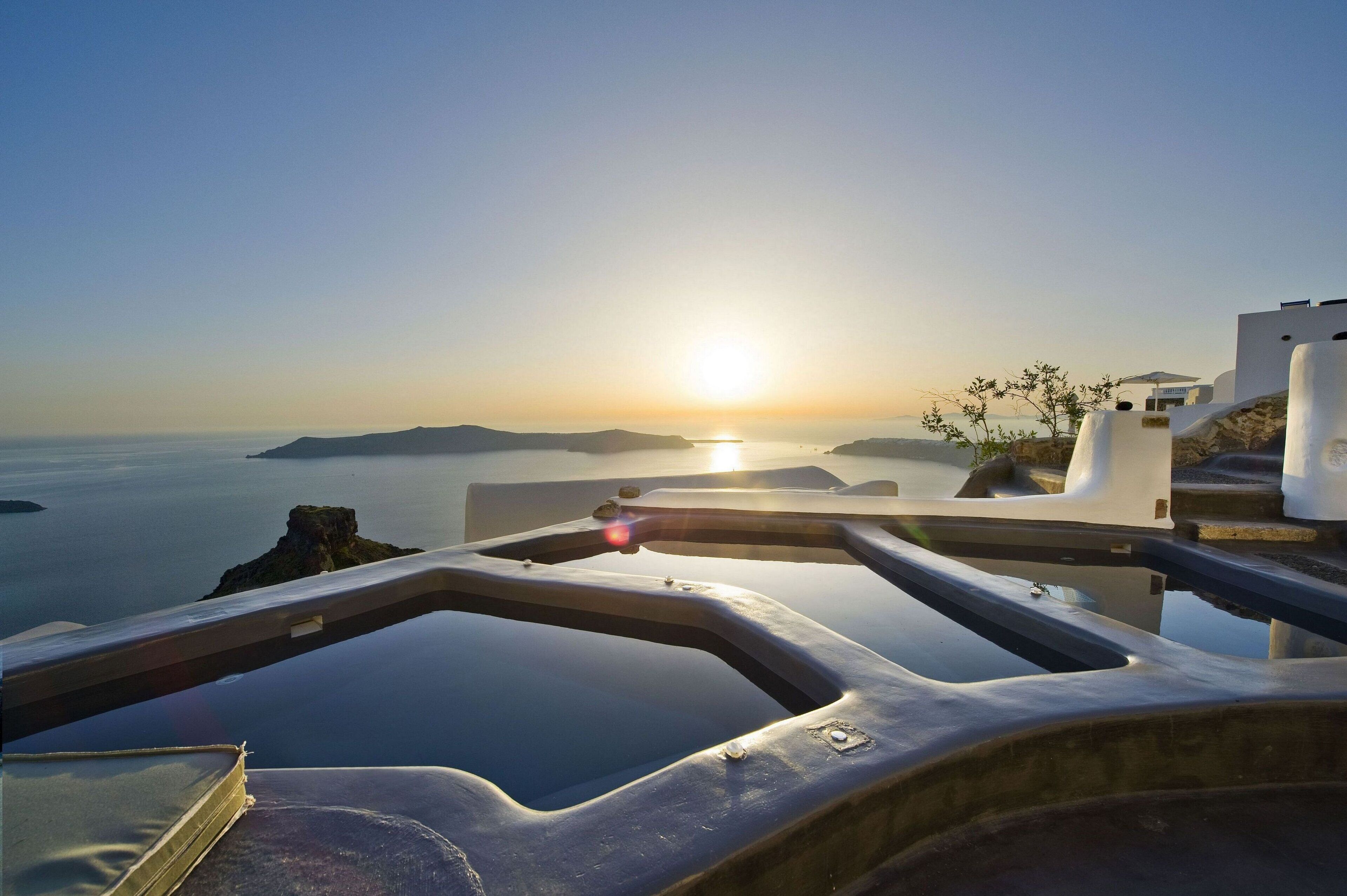 A view from a balcony overlooking a body of water with a sunset in the background.