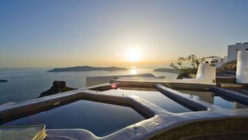 A view from a balcony overlooking a body of water with a sunset in the background.