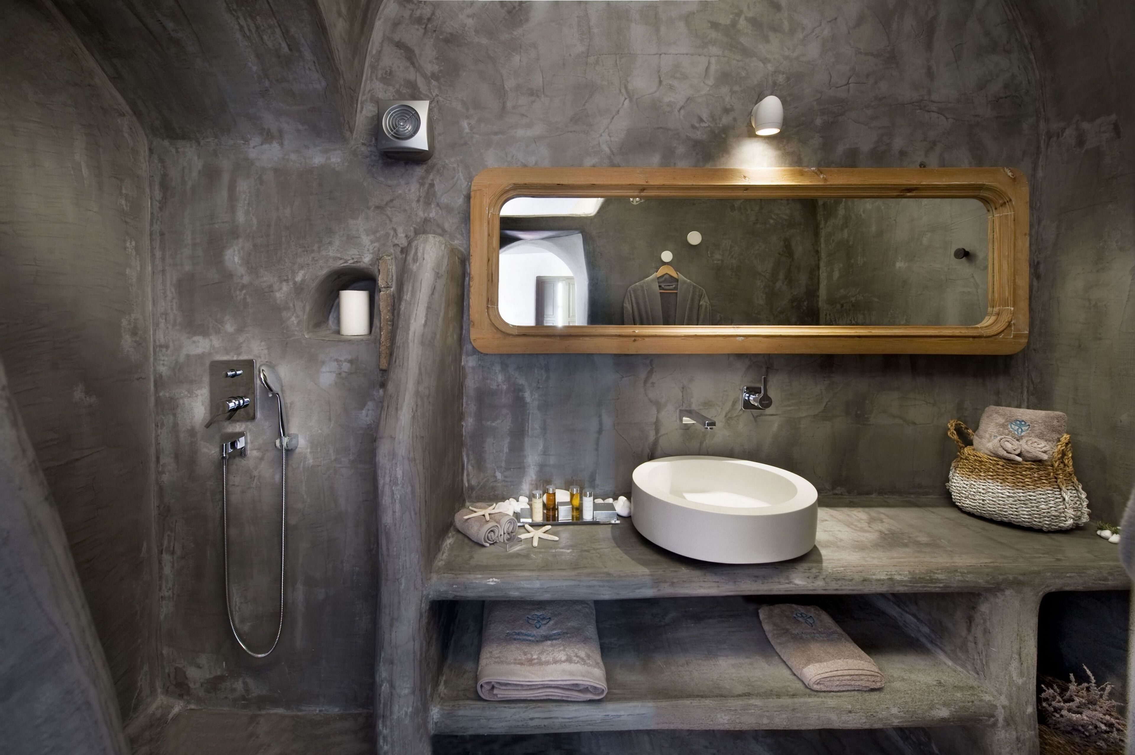 Une salle de bain avec un grand miroir, un lavabo rond et une douche.