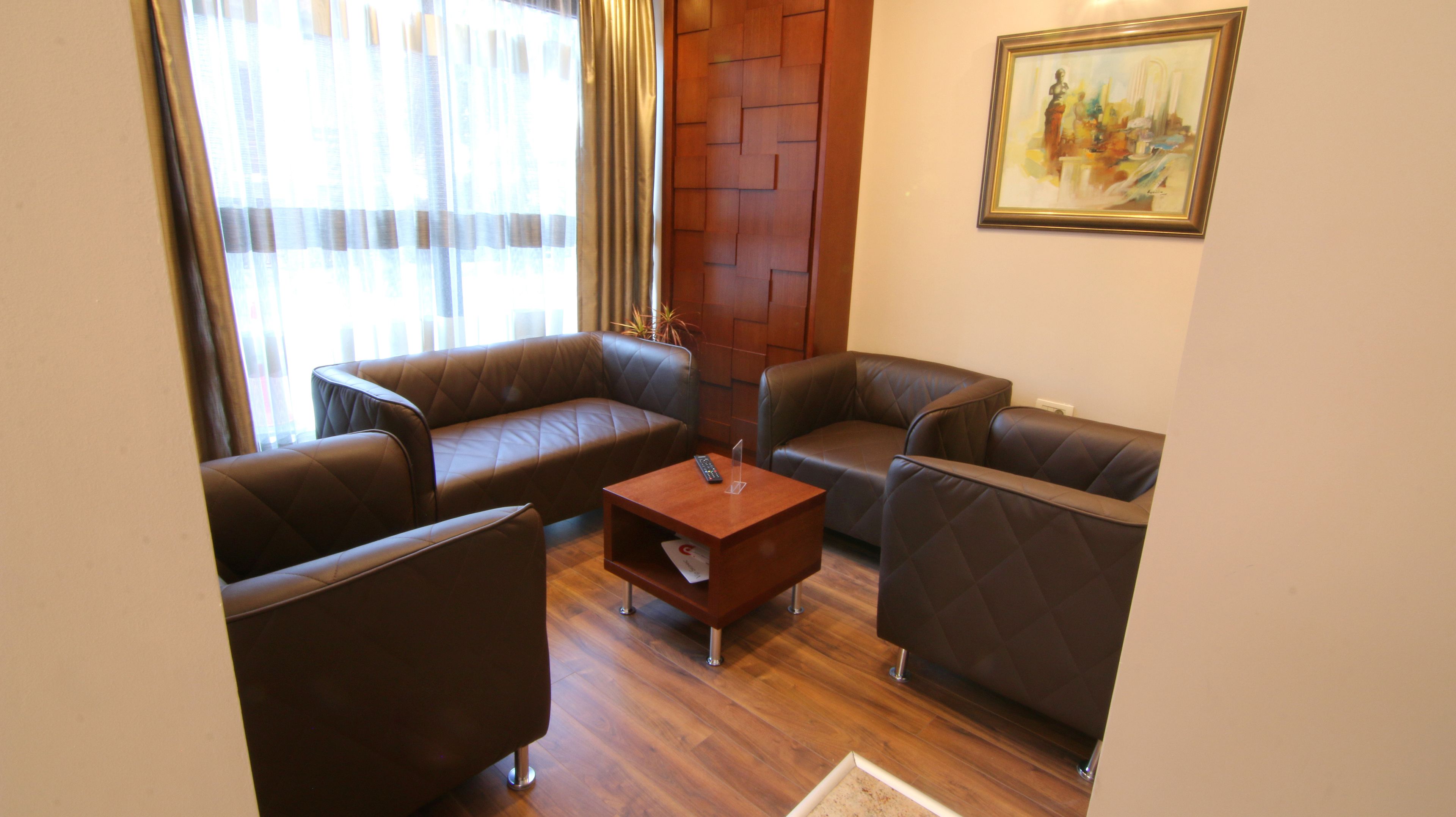 Una habitación con dos sofás de cuero, una mesa de centro de madera y un cuadro en la pared.